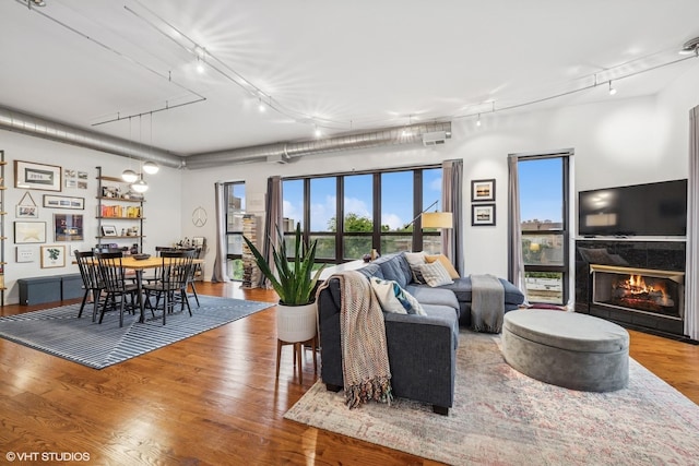 4020 N Damen Ave Unit 408, Chicago, IL 60618 - living area featuring track lighting, wood finished floors, a lit fireplace, and healthy amount of natural light