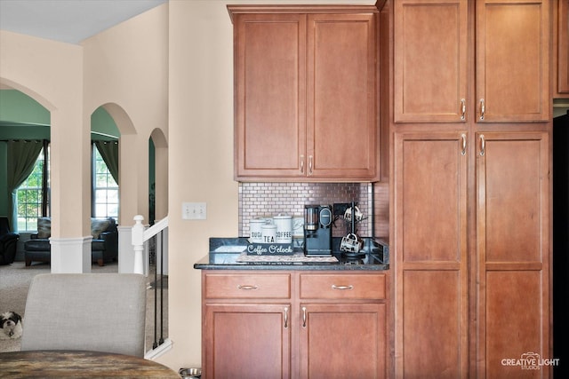1104 Breckenridge Ln, Shorewood, IL 60404 - kitchen with arched walkways, dark stone counters, backsplash, and brown cabinets
