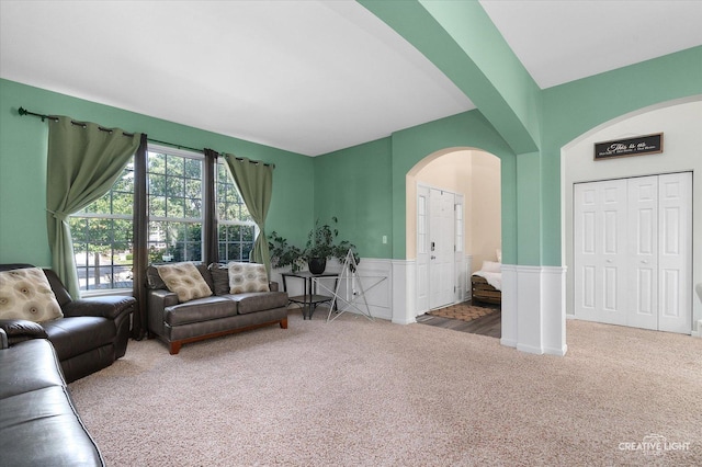 1104 Breckenridge Ln, Shorewood, IL 60404 - living room featuring arched walkways, carpet, and wainscoting