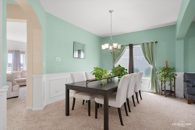 1104 Breckenridge Ln, Shorewood, IL 60404 - carpeted dining room featuring healthy amount of natural light, a chandelier, wainscoting, and arched walkways