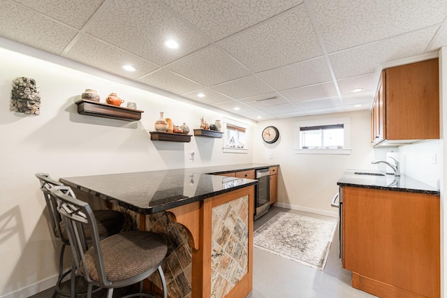 10 N Broadview Ave, Lombard, IL 60148 - kitchen featuring brown cabinetry, baseboards, a paneled ceiling, a peninsula, and a breakfast bar area