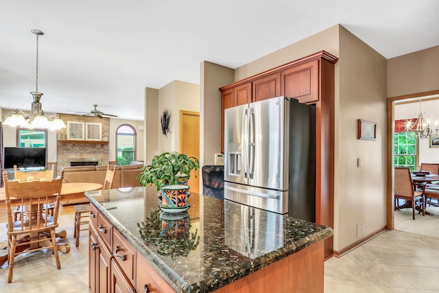 801 Fieldale Ln, Grayslake, IL 60030 - kitchen with stainless steel refrigerator with ice dispenser, a chandelier, a ceiling fan, a brick fireplace, and dark stone counters