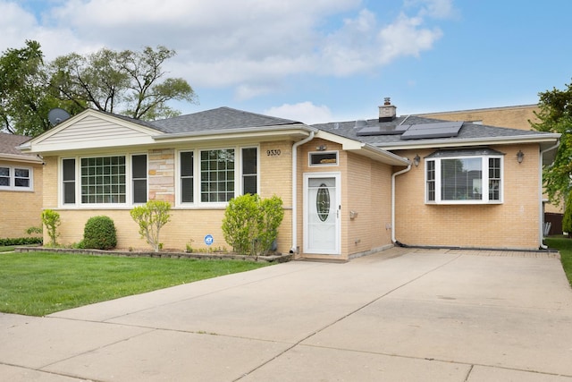 9330 Kolmar Ave, Skokie, IL 60076 - ranch-style house with solar panels, brick siding, a chimney, a front yard, and a shingled roof