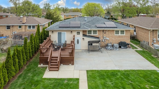 9330 Kolmar Ave, Skokie, IL 60076 - rear view of house with a shingled roof, roof mounted solar panels, a patio, a deck, and a residential view