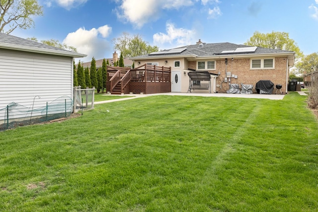 9330 Kolmar Ave, Skokie, IL 60076 - rear view of property featuring a wooden deck, a patio area, solar panels, brick siding, and stairway
