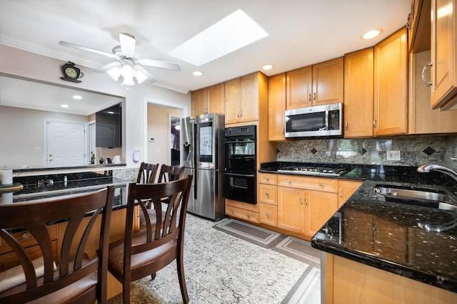9330 Kolmar Ave, Skokie, IL 60076 - kitchen with appliances with stainless steel finishes, a sink, a skylight, a ceiling fan, and decorative backsplash