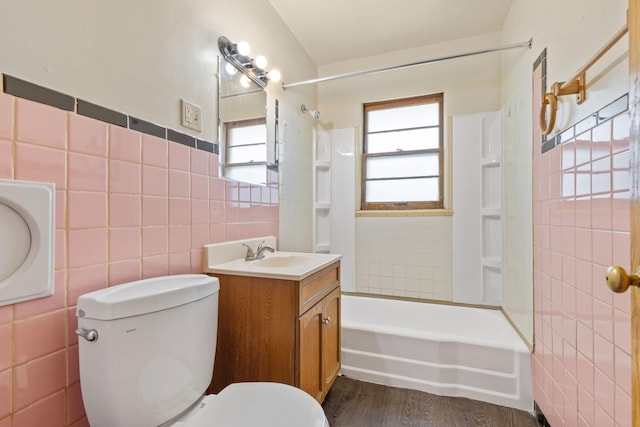 3229 Liberty Dr, Rockford, IL 61101 - full bath featuring tile walls, shower / washtub combination, toilet, vanity, and wood finished floors