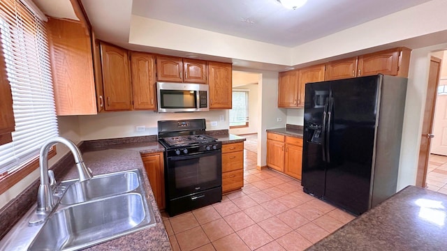 3420 203rd St, Olympia Fields, IL 60461 - kitchen featuring black appliances, a sink, dark countertops, light tile patterned floors, and brown cabinetry