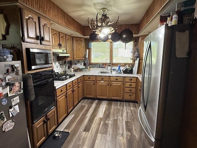 11109 US Highway 14, Woodstock, IL 60098 - kitchen featuring appliances with stainless steel finishes, brown cabinetry, light countertops, a chandelier, and wood finished floors