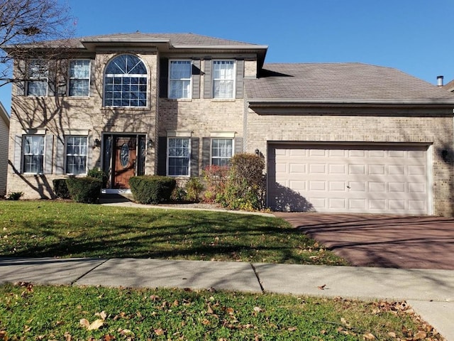 520 Carriage Way S, Elgin, IL 60177 - colonial-style house with driveway, a garage, brick siding, and a front lawn