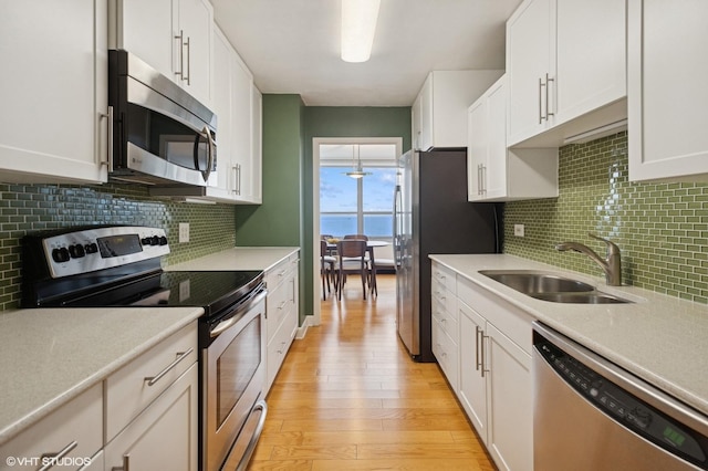 3550 N Lake Shore Dr Unit 1901, Chicago, IL 60657 - kitchen with stainless steel appliances, a sink, light wood-type flooring, and white cabinetry