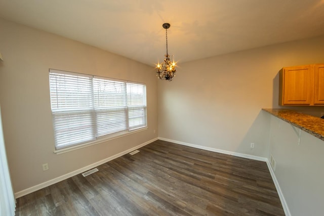 2433 River Oaks Ln Unit 6, Rockford, IL 61102 - unfurnished dining area featuring a chandelier, dark wood-type flooring, and baseboards