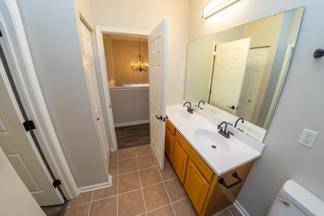 2433 River Oaks Ln Unit 6, Rockford, IL 61102 - bathroom featuring double vanity, a chandelier, toilet, tile patterned floors, and baseboards