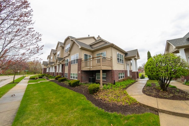 2433 River Oaks Ln Unit 6, Rockford, IL 61102 - view of property exterior with brick siding, a lawn, and a balcony