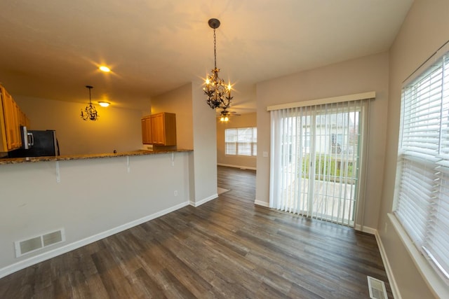 2433 River Oaks Ln Unit 6, Rockford, IL 61102 - kitchen with brown cabinetry, dark wood-type flooring, a chandelier, and baseboards
