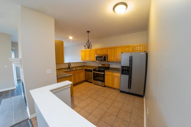 2433 River Oaks Ln Unit 6, Rockford, IL 61102 - kitchen featuring appliances with stainless steel finishes, a sink, light tile patterned floors, decorative light fixtures, and dark countertops