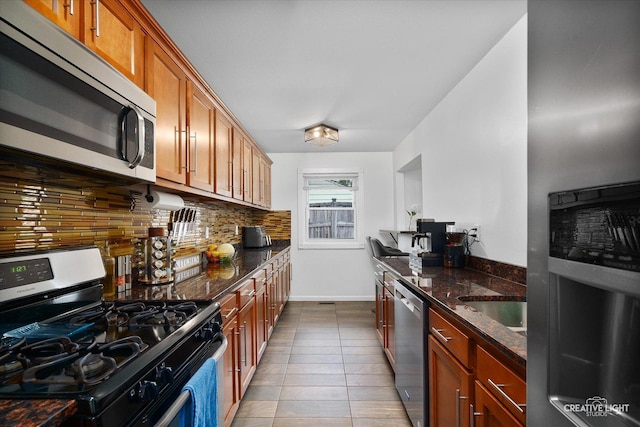 125 S Pinecrest Rd, Bolingbrook, IL 60440 - kitchen with stainless steel appliances, backsplash, dark stone counters, tile patterned flooring, and brown cabinetry