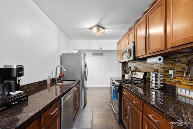 125 S Pinecrest Rd, Bolingbrook, IL 60440 - kitchen featuring stainless steel appliances, decorative backsplash, brown cabinetry, and dark stone countertops