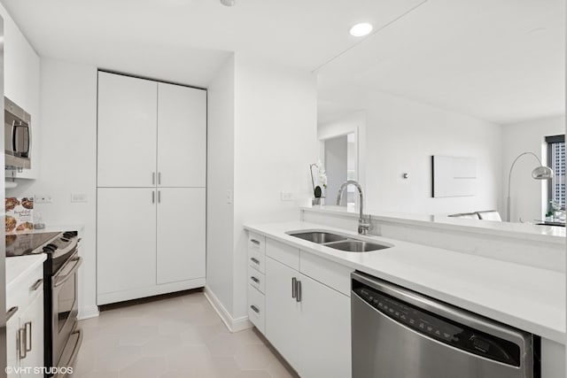 130 N Garland Ct Unit 2009, Chicago, IL 60602 - kitchen featuring stainless steel appliances, a sink, light countertops, light tile patterned floors, and white cabinets