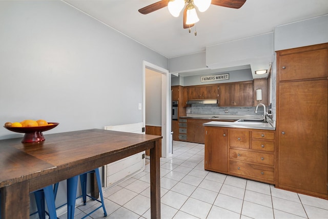 1211 Schriber Ave, Joliet, IL 60435 - kitchen with a ceiling fan, light tile patterned floors, under cabinet range hood, tasteful backsplash, and stainless steel oven