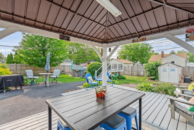 1211 Schriber Ave, Joliet, IL 60435 - deck featuring a storage shed, outdoor dining area, a fenced backyard, and a patio area