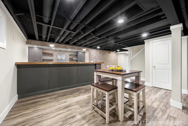 112 Danada Dr, Wheaton, IL 60189 - dining space featuring bar area, baseboards, wood finished floors, and brick wall
