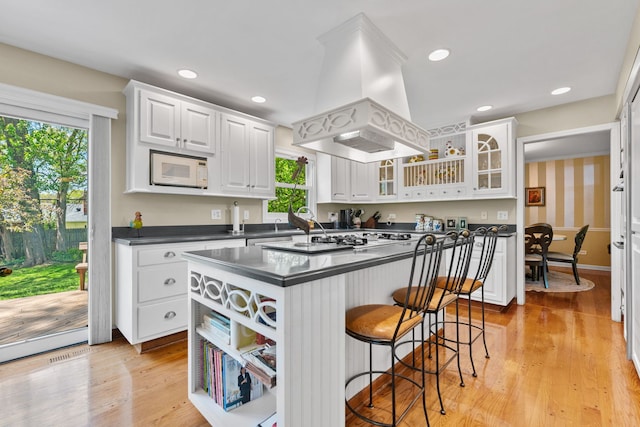 846 Park Dr, Flossmoor, IL 60422 - kitchen with island range hood, dark countertops, white cabinetry, white microwave, and recessed lighting