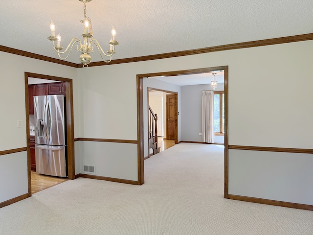 1463 Lantern Cir, Naperville, IL 60540 - unfurnished room featuring light carpet, a chandelier, baseboards, crown molding, and a textured ceiling