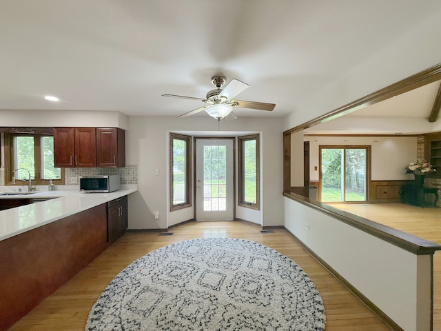 1463 Lantern Cir, Naperville, IL 60540 - kitchen featuring stainless steel microwave, tasteful backsplash, light countertops, light wood-style floors, and a ceiling fan