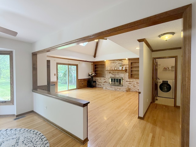 1463 Lantern Cir, Naperville, IL 60540 - living area with a brick fireplace, light wood-style floors, washing machine and dryer, and baseboards