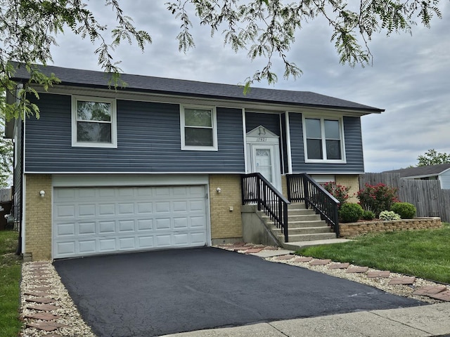 17921 Normandy Ln, Hazel Crest, IL 60429 - raised ranch featuring brick siding, asphalt driveway, and an attached garage