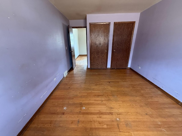 1235 S Mannheim Rd, Westchester, IL 60154 - unfurnished bedroom with two closets, baseboards, and wood finished floors