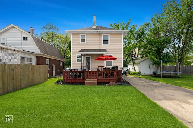 712 Lebanon St, Aurora, IL 60505 - back of property with a trampoline and a wooden deck