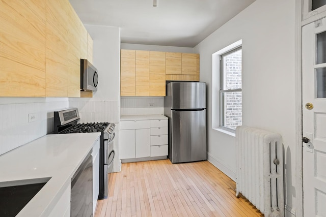 847 S Humphrey Ave Unit 3, Oak Park, IL 60304 - kitchen featuring appliances with stainless steel finishes, radiator, light countertops, and light wood-type flooring