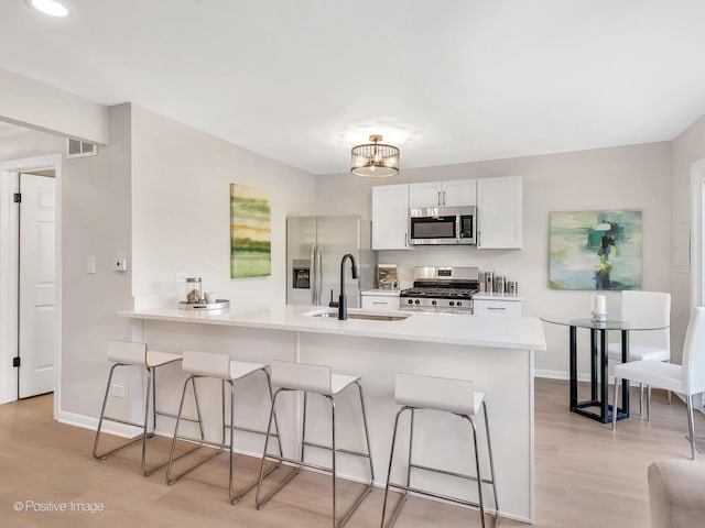 729 Bolton Way, Hanover Park, IL 60133 - kitchen with appliances with stainless steel finishes, a sink, a breakfast bar area, and light wood-type flooring