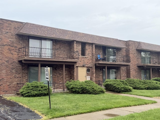 22633 Pleasant Dr Unit 11B, Richton Park, IL 60471 - view of front facade featuring a balcony, a front lawn, and brick siding