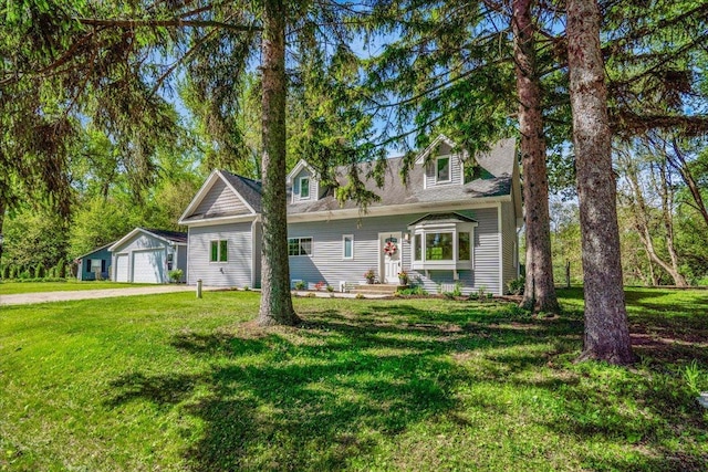 2425 W Riverside Dr, Mchenry, IL 60050 - new england style home featuring a detached garage, a front yard, an outbuilding, and driveway