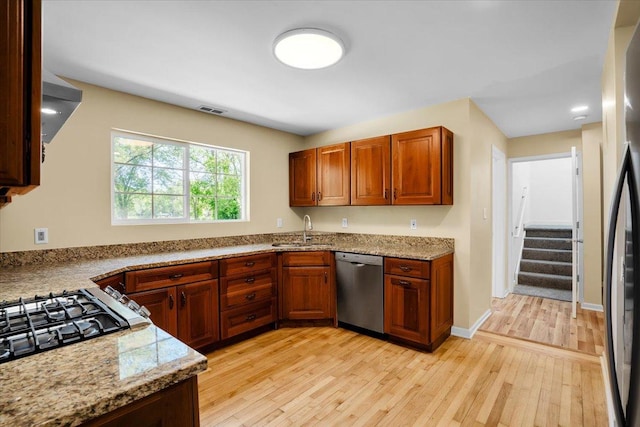 2425 W Riverside Dr, Mchenry, IL 60050 - kitchen with appliances with stainless steel finishes, a sink, light wood-style floors, light stone counters, and brown cabinetry