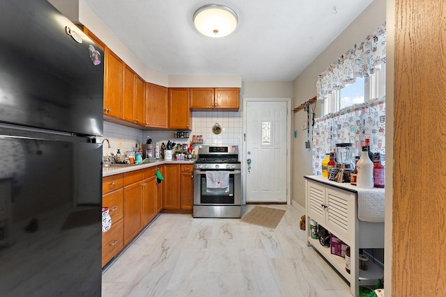 1678 State Line Rd, Calumet City, IL 60409 - kitchen featuring freestanding refrigerator, stainless steel range with gas stovetop, light marble finish floors, light countertops, and decorative backsplash