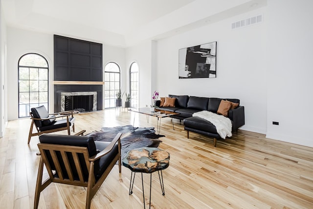 1620 Devonshire Ln, Lake Forest, IL 60045 - living room featuring a tray ceiling, light wood-style flooring, a fireplace, and baseboards