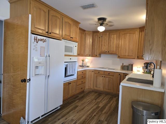 202 W Archer Ave, La Harpe, IL 62321 - kitchen featuring white appliances, a sink, dark wood-style floors, light countertops, and ceiling fan