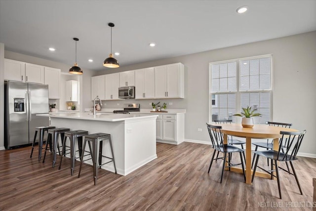 16017 S Crescent Ln, Plainfield, IL 60586 - kitchen with stainless steel appliances, wood finished floors, white cabinets, a center island with sink, and recessed lighting