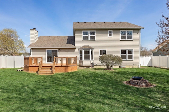 1345 William St, Sycamore, IL 60178 - rear view of house with a fire pit, a fenced backyard, a chimney, a wooden deck, and a shingled roof