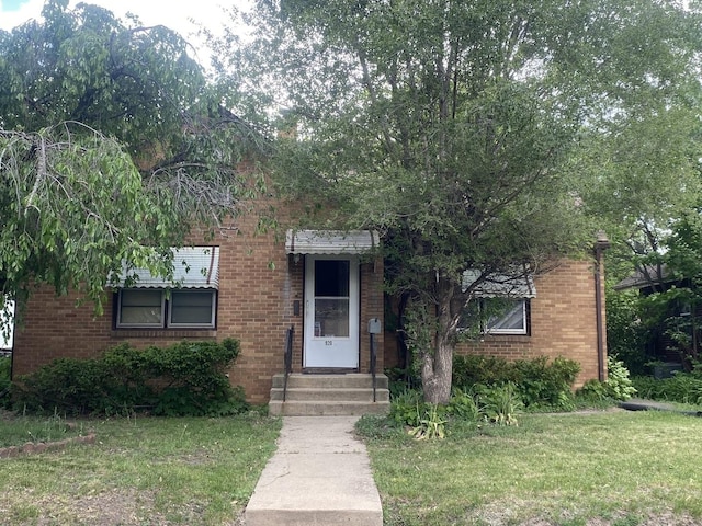 920 16th St, Rockford, IL 61104 - view of front of home with brick siding, entry steps, and a front lawn