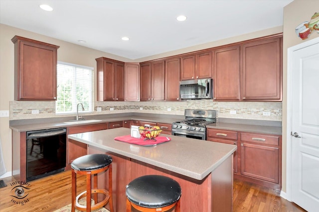 17022 S Creighton Dr, Lockport, IL 60441 - kitchen with appliances with stainless steel finishes, a sink, light wood-type flooring, a kitchen breakfast bar, and a center island
