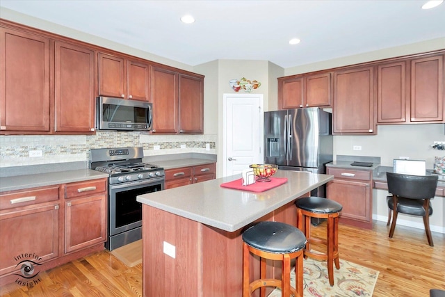 17022 S Creighton Dr, Lockport, IL 60441 - kitchen featuring appliances with stainless steel finishes, a kitchen breakfast bar, a center island, light wood-style flooring, and recessed lighting