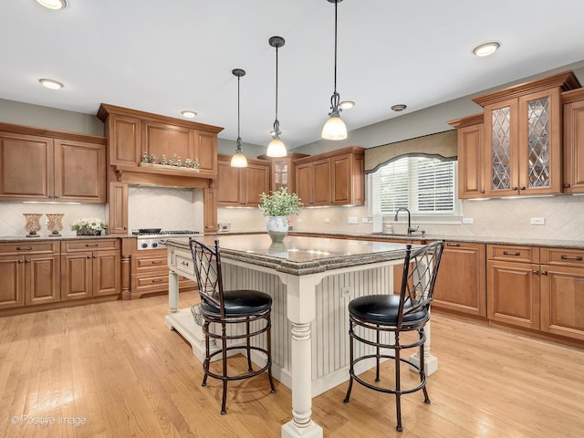 158 Los Lagos Dr, Bloomingdale, IL 60108 - kitchen featuring a kitchen bar, light wood-style floors, brown cabinets, stainless steel gas stovetop, and recessed lighting