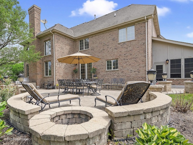 158 Los Lagos Dr, Bloomingdale, IL 60108 - back of property with a fire pit, brick siding, a chimney, and a patio area