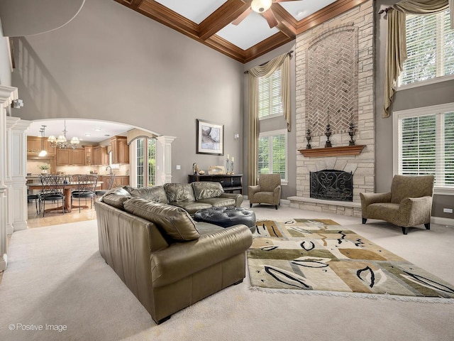 158 Los Lagos Dr, Bloomingdale, IL 60108 - living room featuring a high ceiling, arched walkways, a stone fireplace, a ceiling fan, and a chandelier