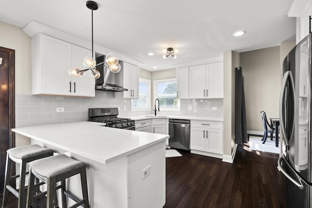 304 Turnbridge Dr, Shorewood, IL 60404 - kitchen with stainless steel appliances, wall chimney exhaust hood, a sink, dark wood-type flooring, and a peninsula